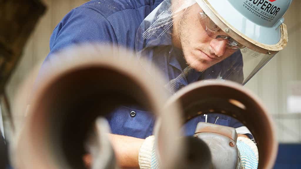 Man closely inspecting pipes