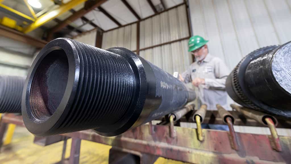 A man working on a large pipe on a table