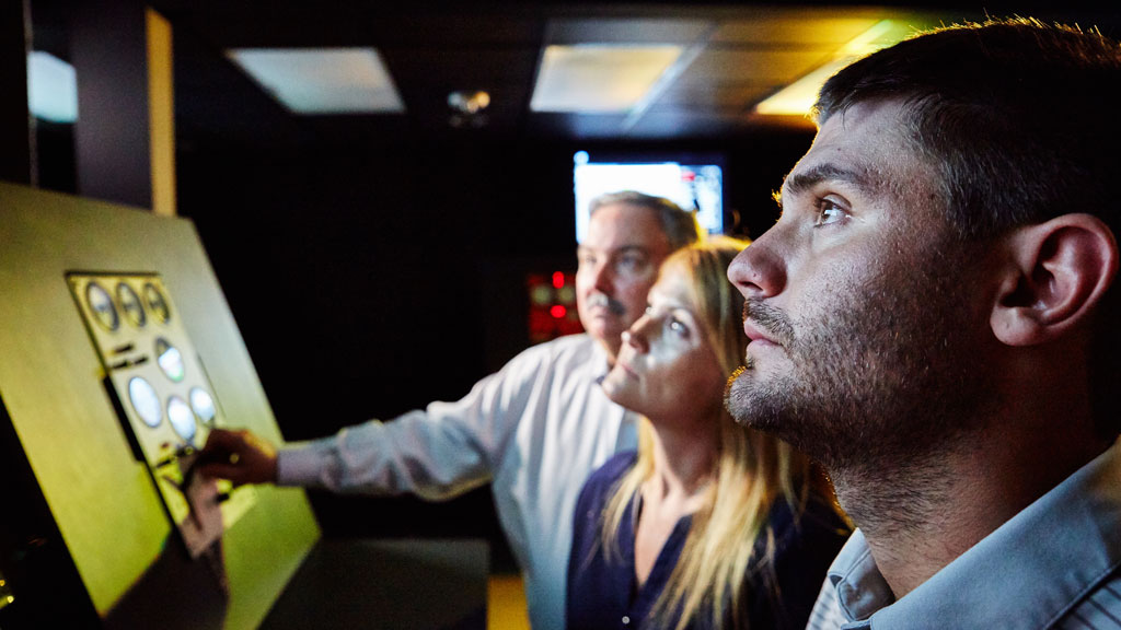 Offshore technicians monitoring rig performance on monitors